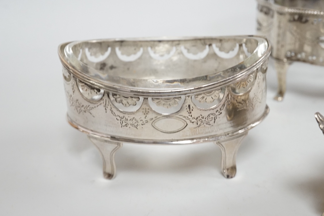 A pair of George III pierced silver shaped oval salts by Hester Bateman, London, 1783 (a.f.), with clear glass liners, together with one other George III silver oval salt, London, 1783 and two later silver mustard pots.